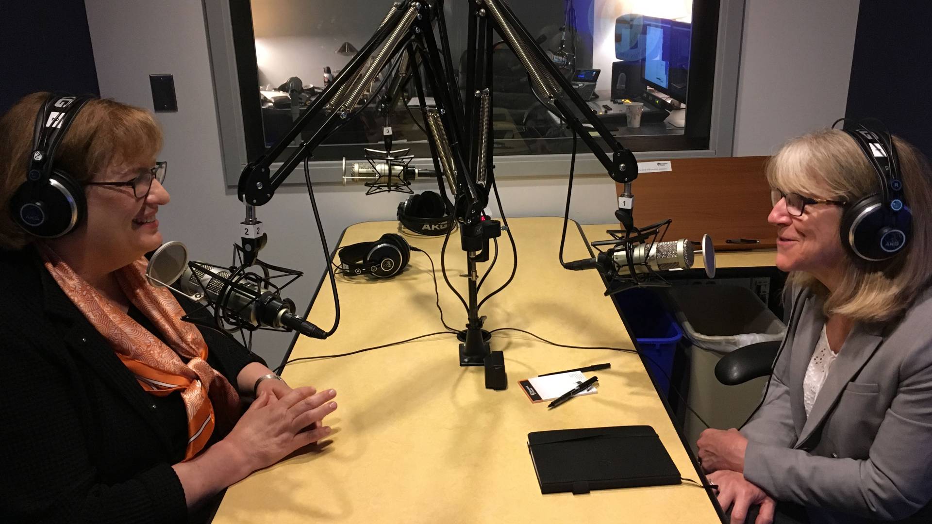 Patricia Falcone and Margaret Koval in studio booth recording podcast