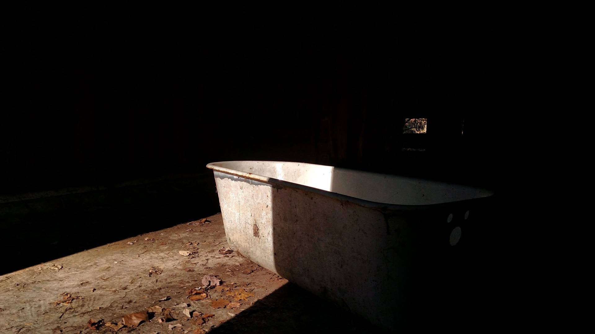 Photograph of an old bath tub in shadow