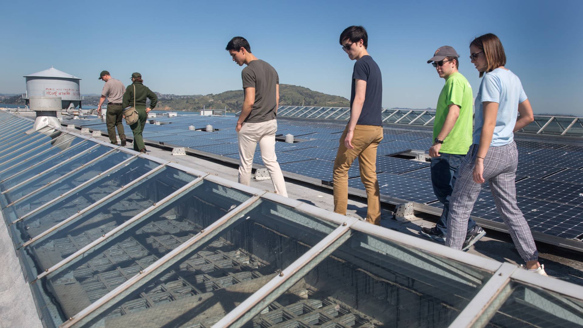 Students walking on rooftop with solar panels in the background