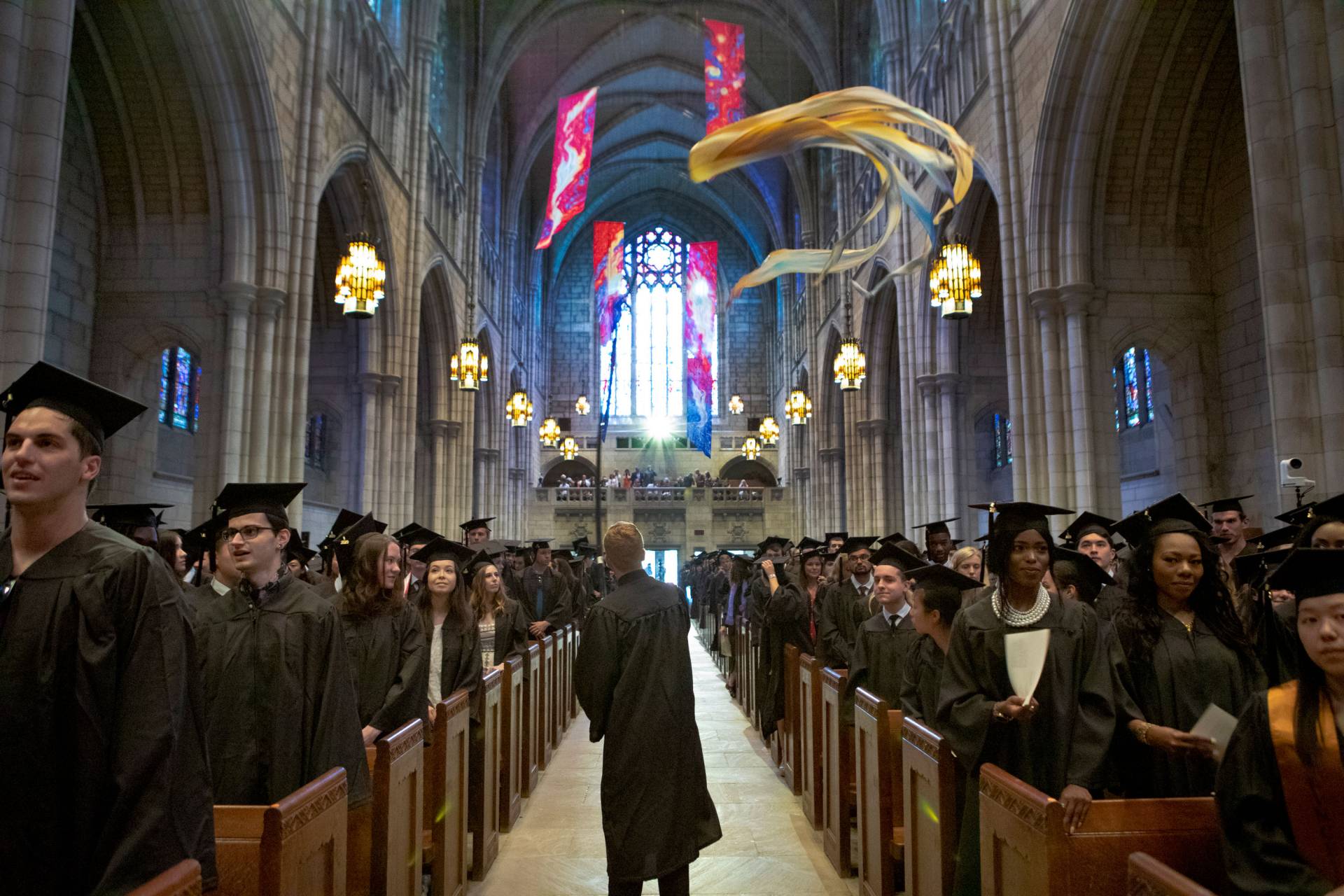 Students wave kites during procession into the chapel