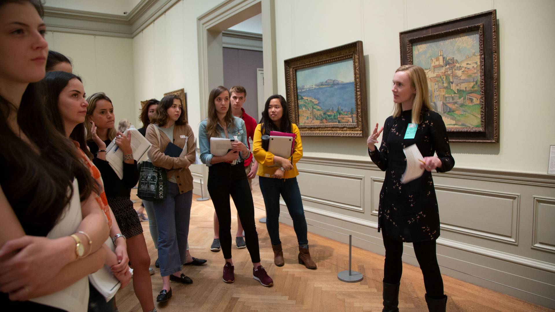 Bridget Alsdorf speaking with students in front of art