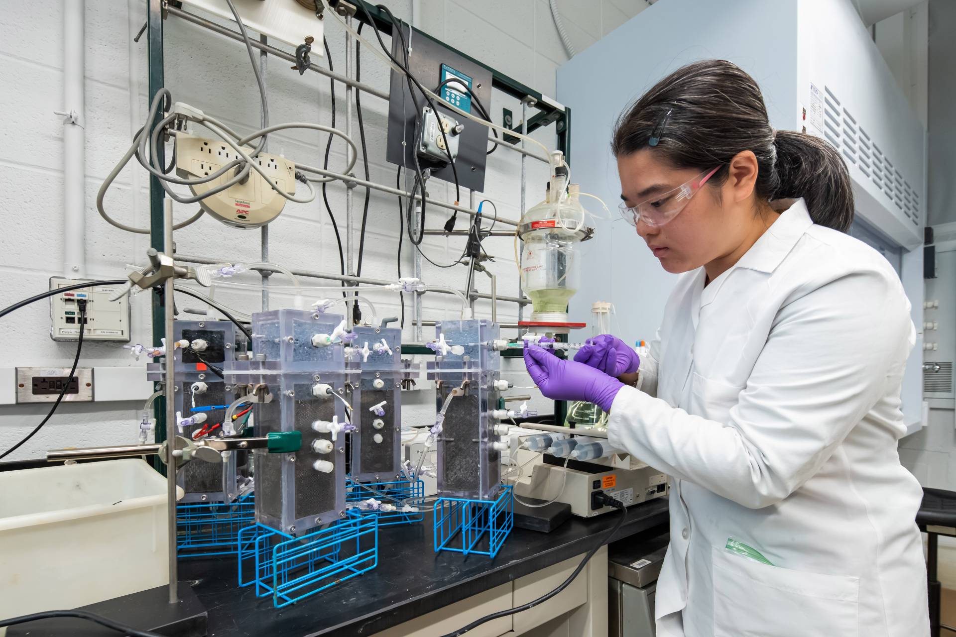 A researcher checks on a machine that analyzes samples