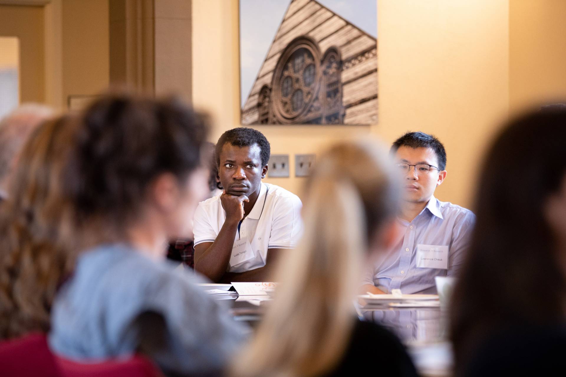 Faculty listen intently while sitting around a table