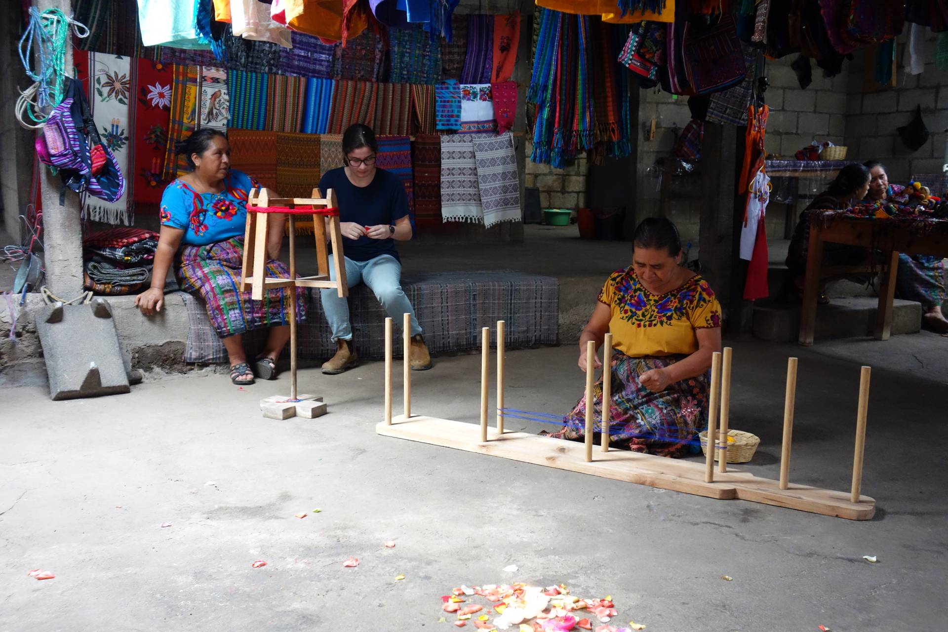 A student sits with 2 weavers