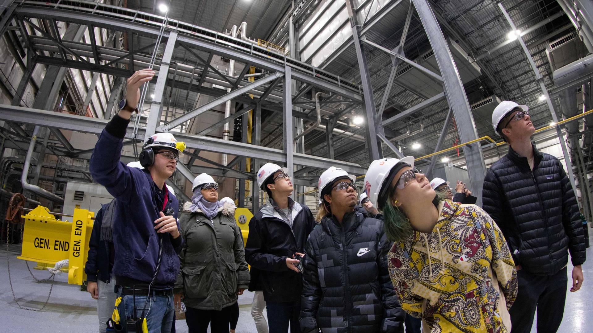 Students look up during a tour of a power plant