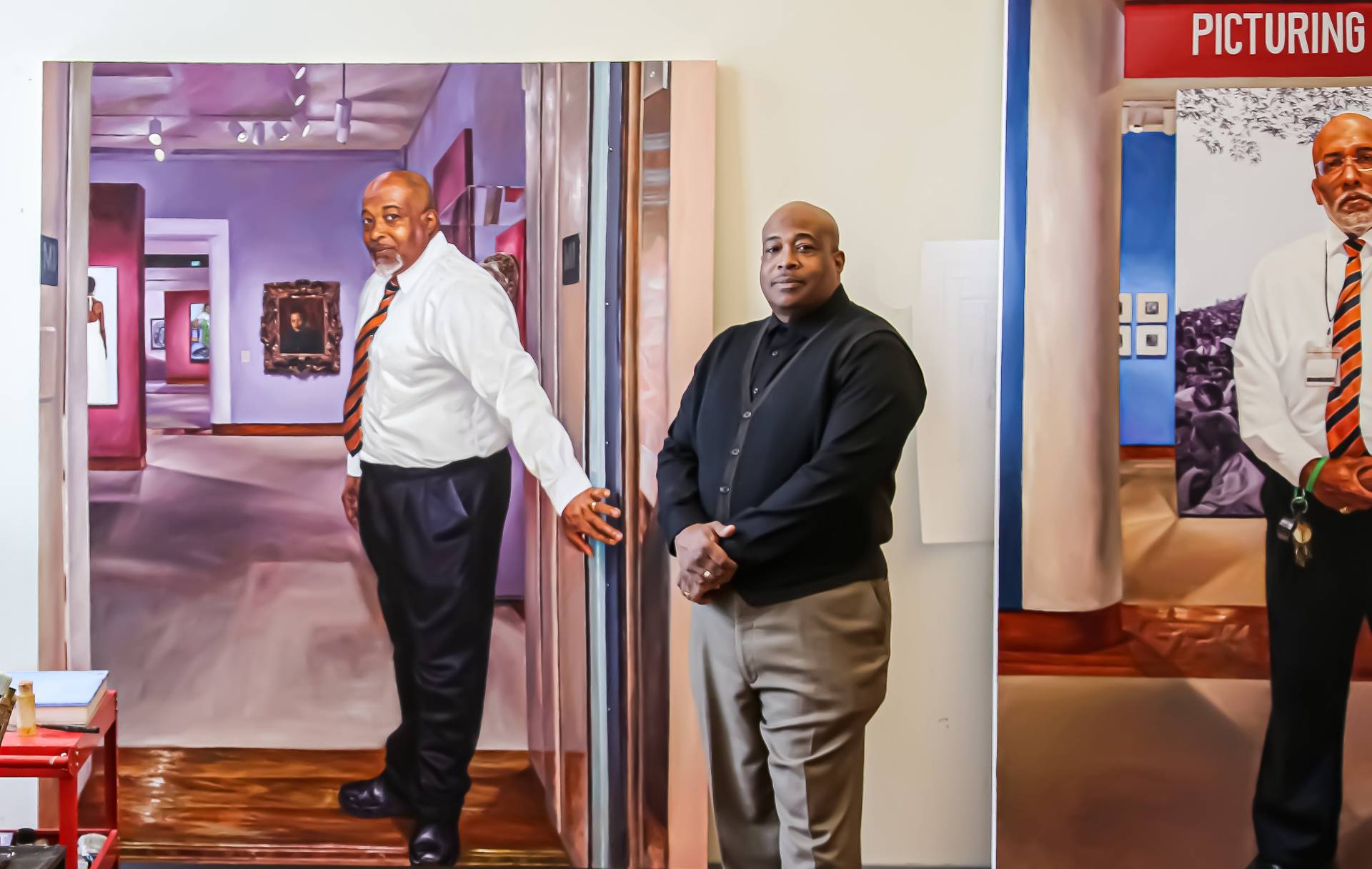 Michael Moore stands next to his portrait painted by Mario Moore