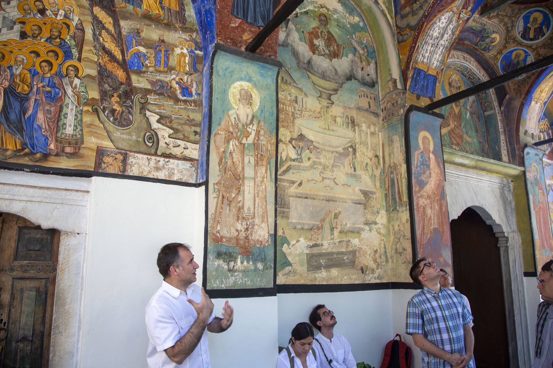 A lecturer talks about the Byzantine paintings on the walls of the monastery