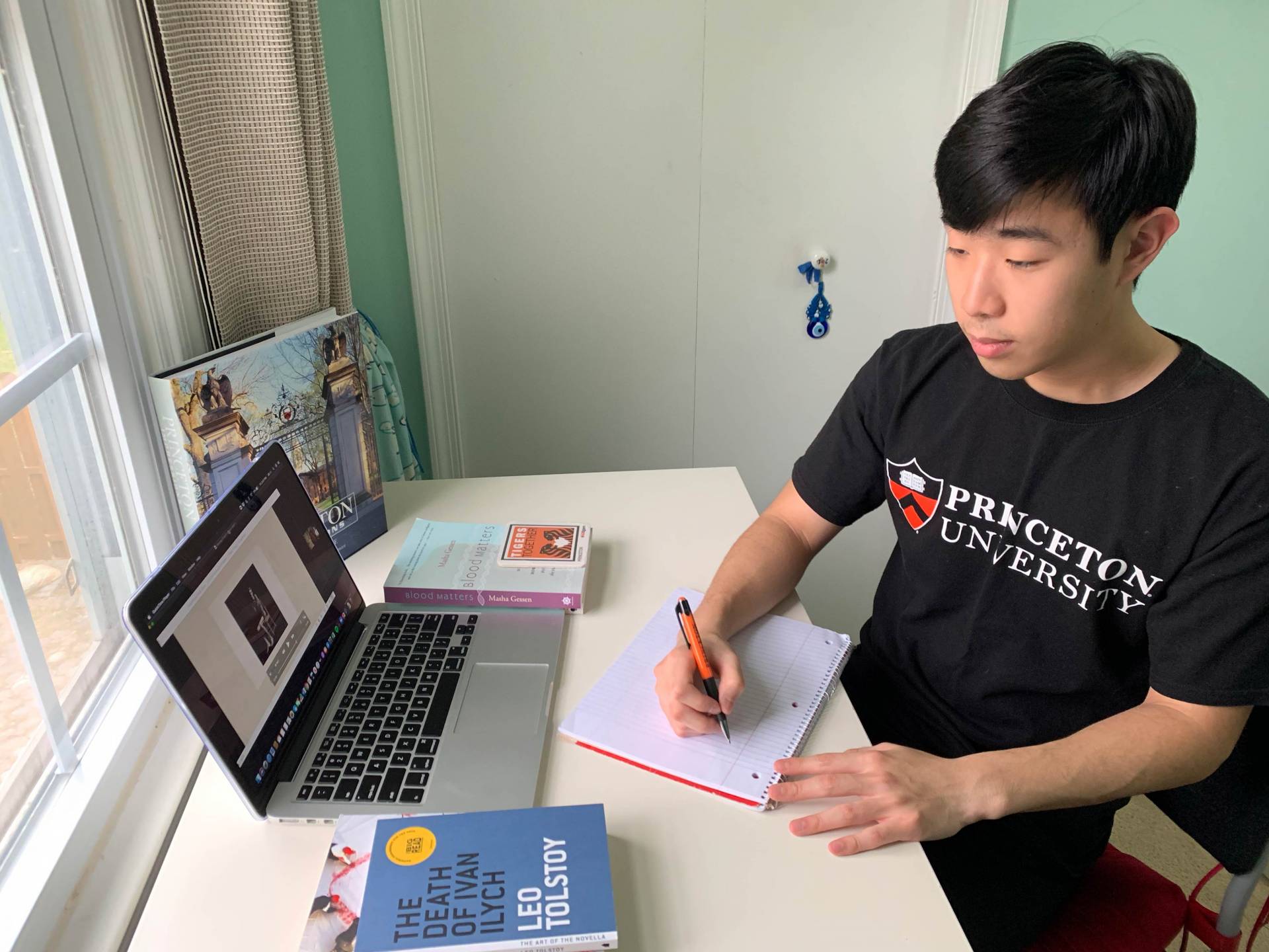 Jason Hong studies at a table in front of a laptop