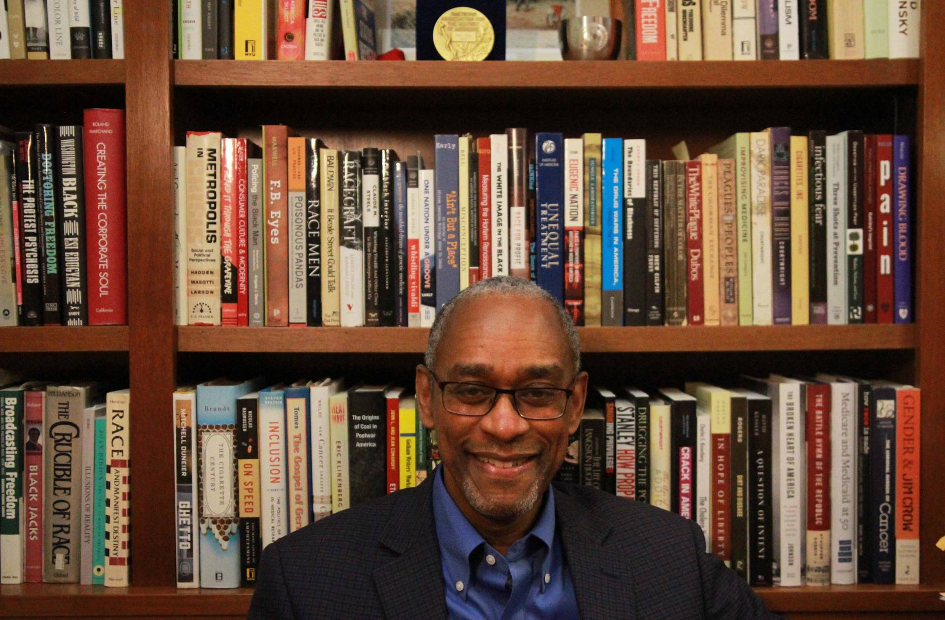 Keith Wailoo in front of his bookshelves