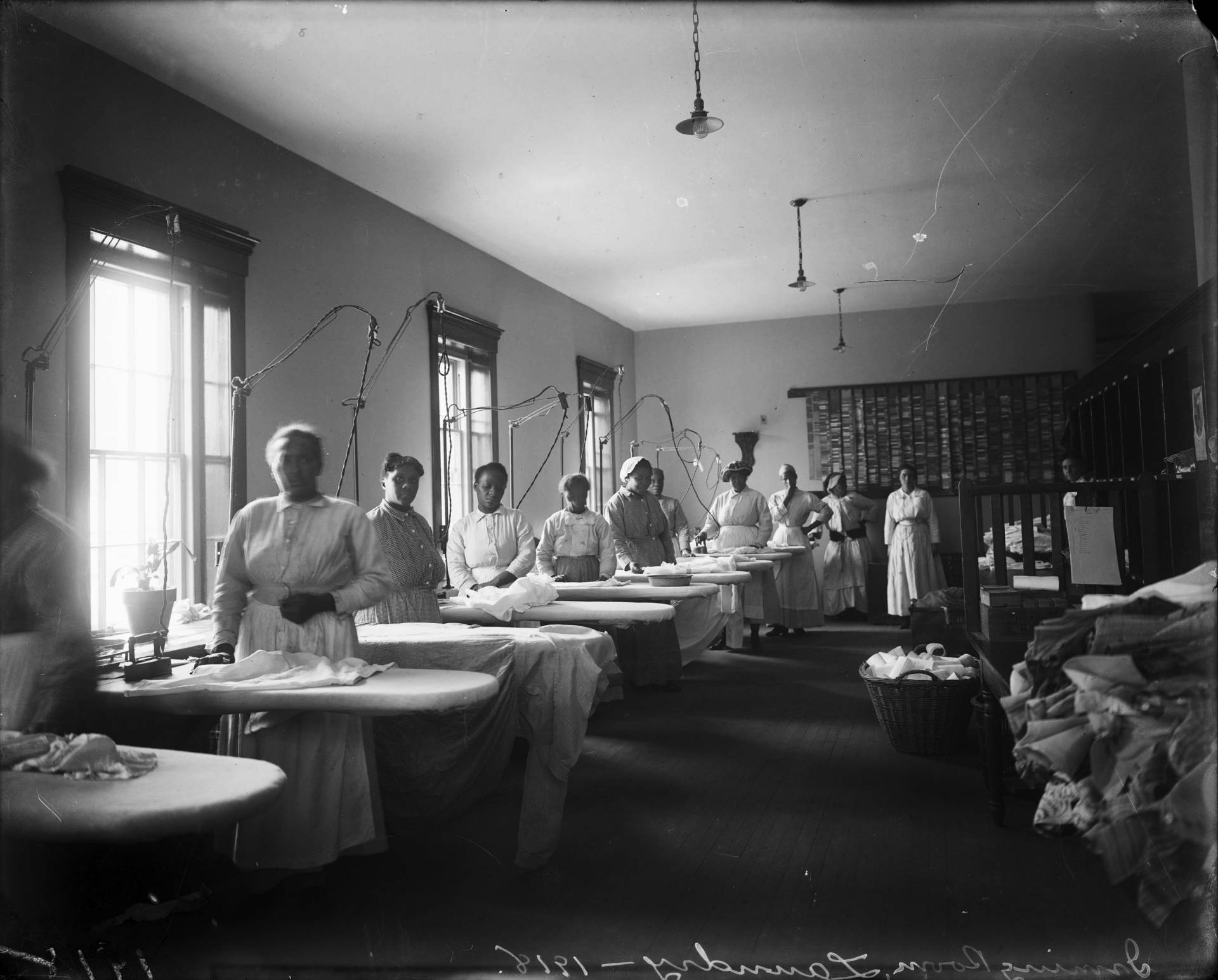 A row of Black women standing at ironing boards