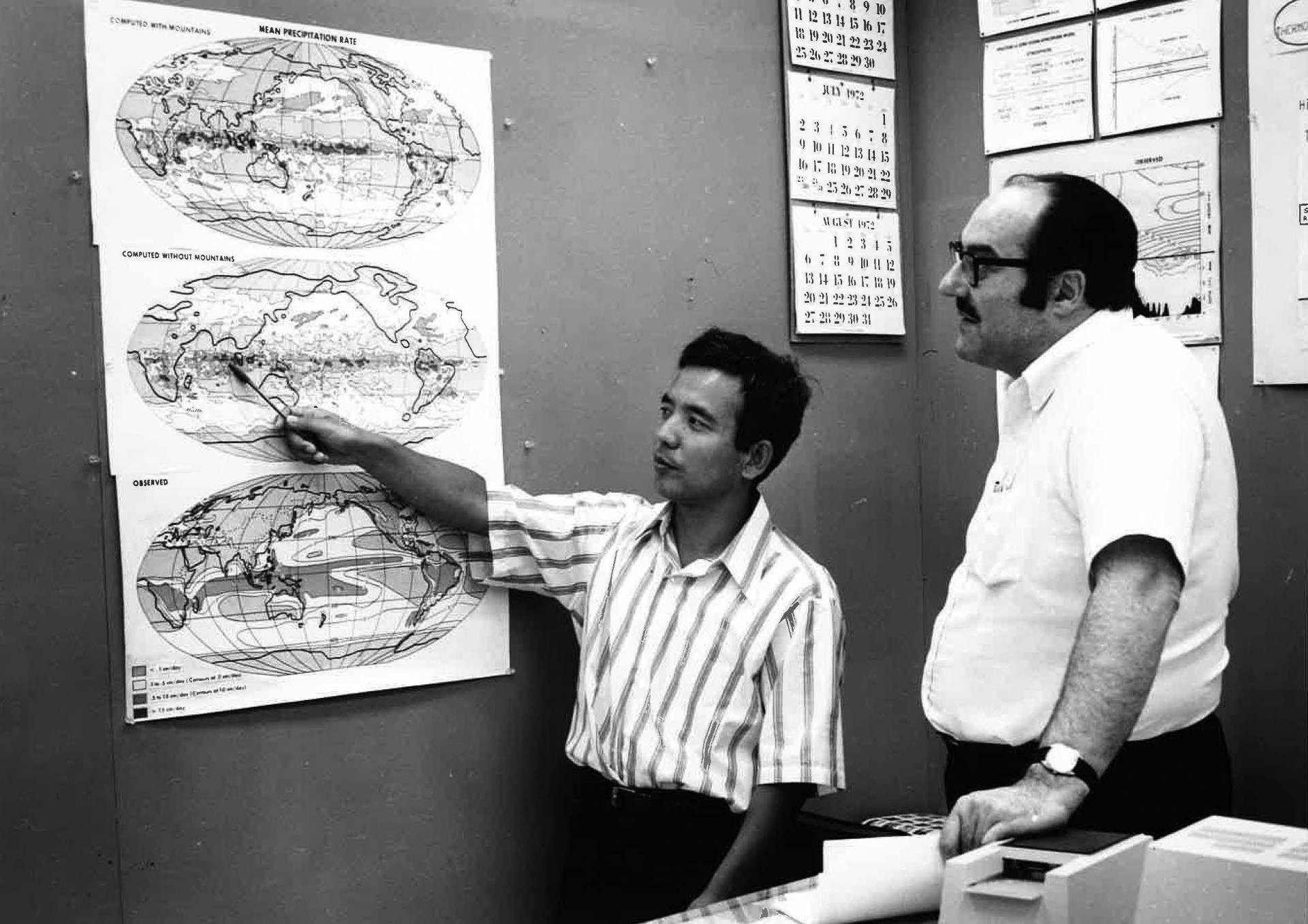 Manabe points at a map with a colleague in the 1960s