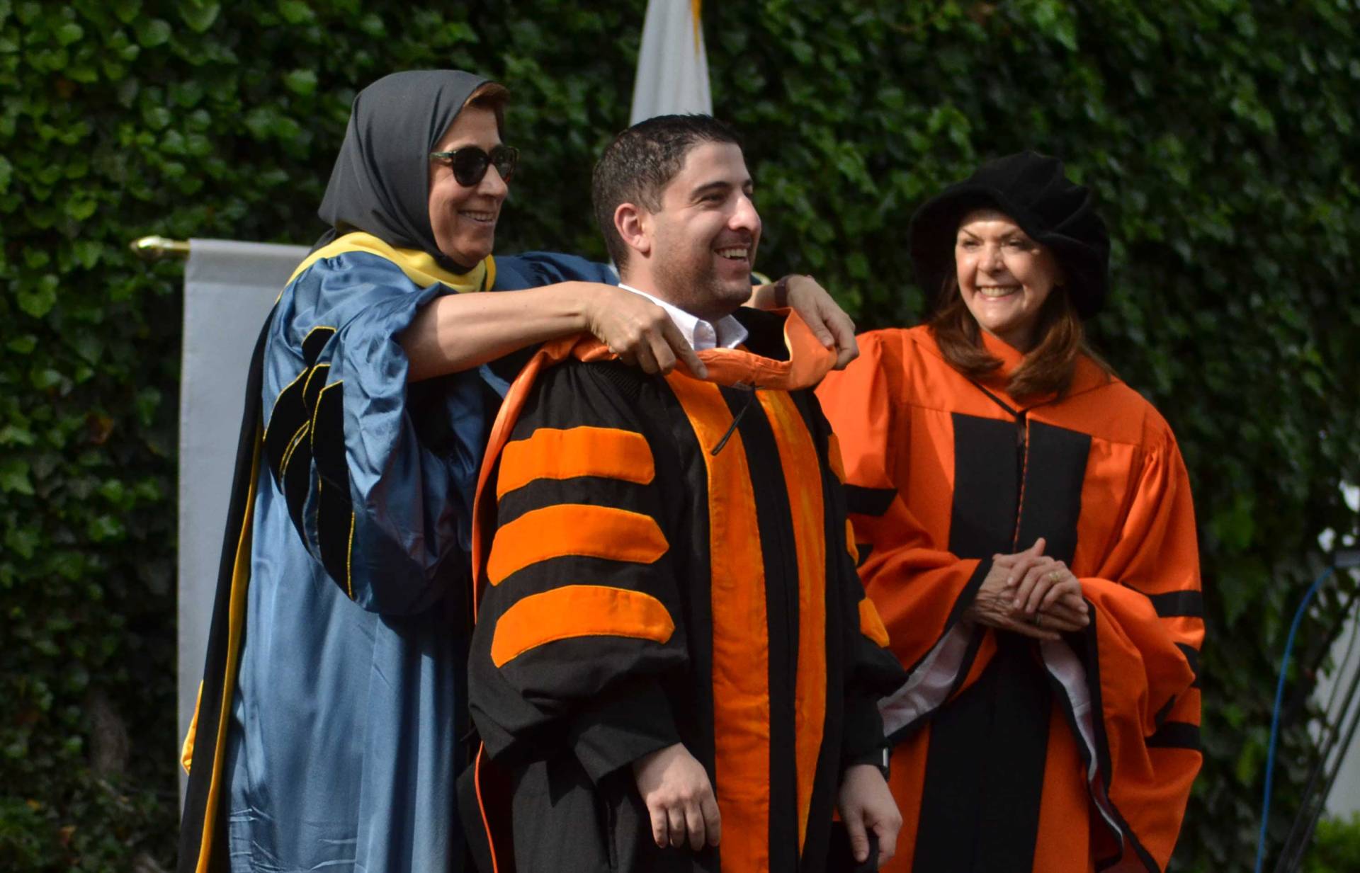 A student is hooded by Amaney Jamal, his advisor