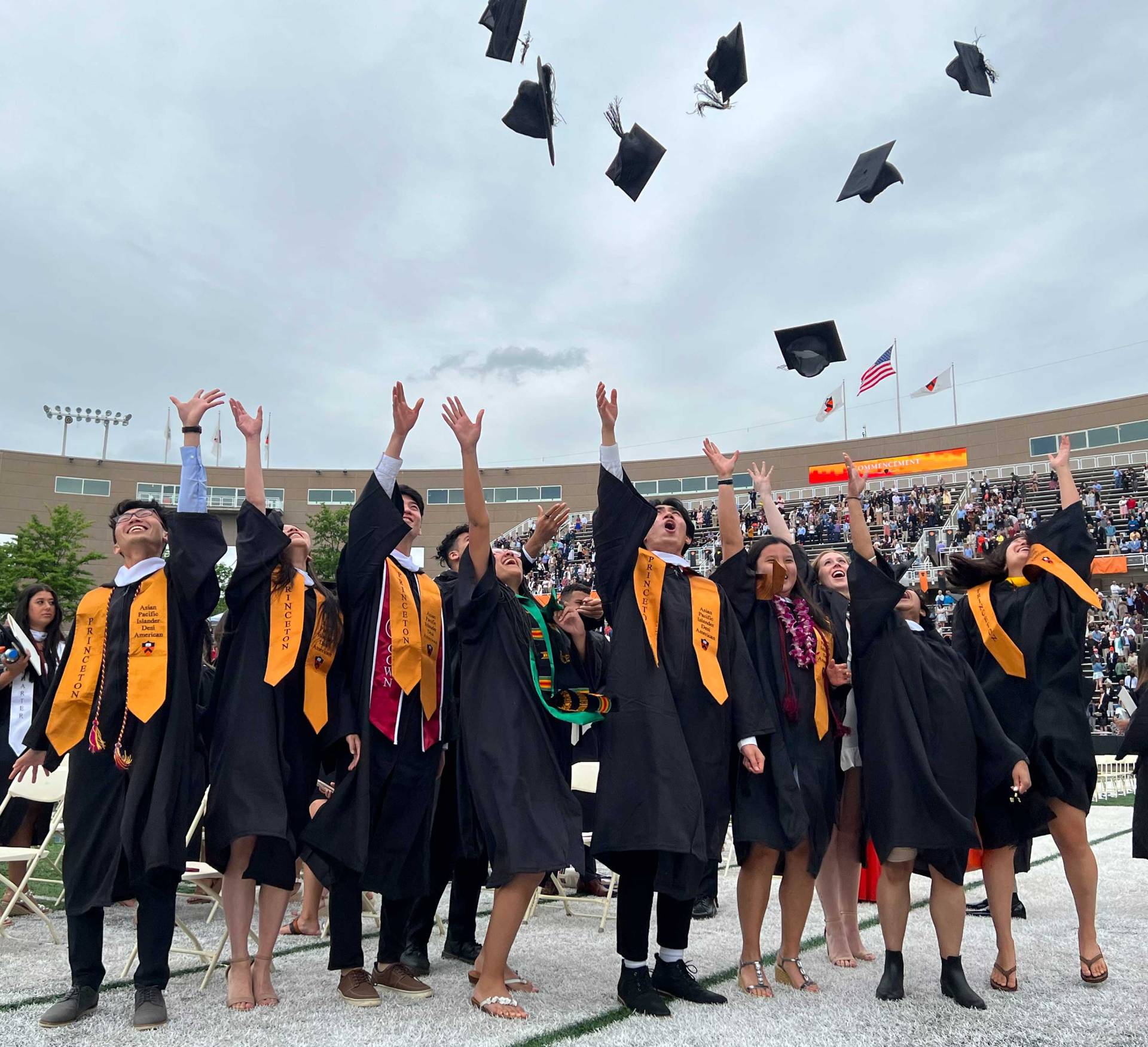 A group of graduating students throw their caps into the air