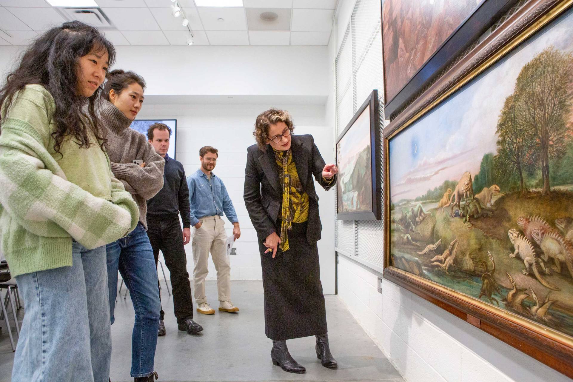 Prof DeLue points to a painting