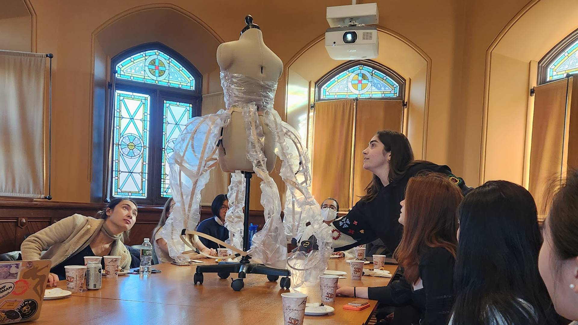 Students discuss a dress on a dress form duing the class