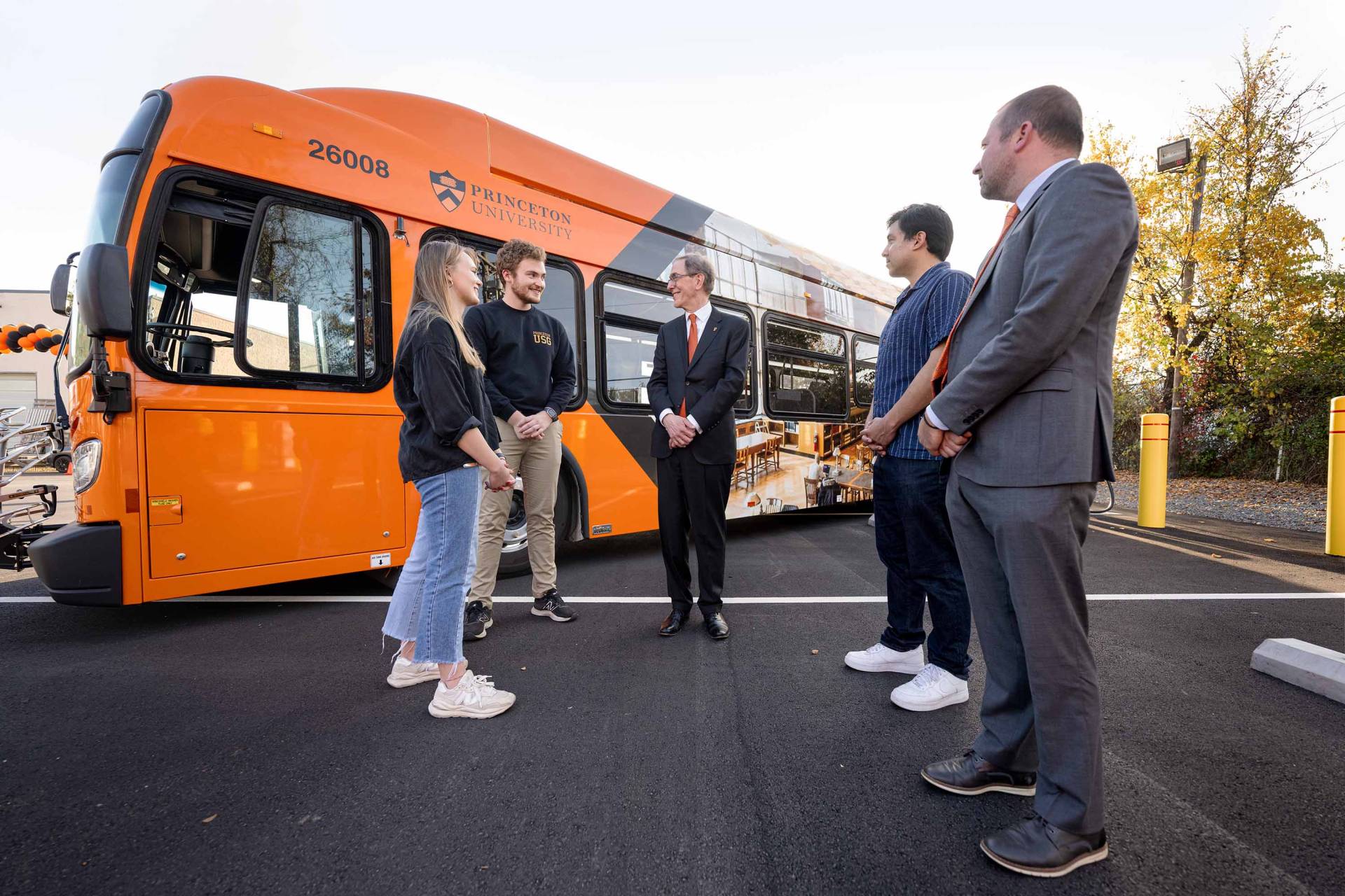 President Eisgruber standing in front of an electric bus with other people