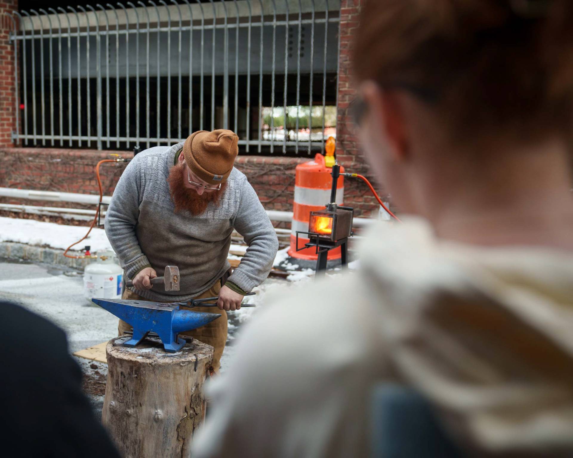A person hammering metal on an anvil.