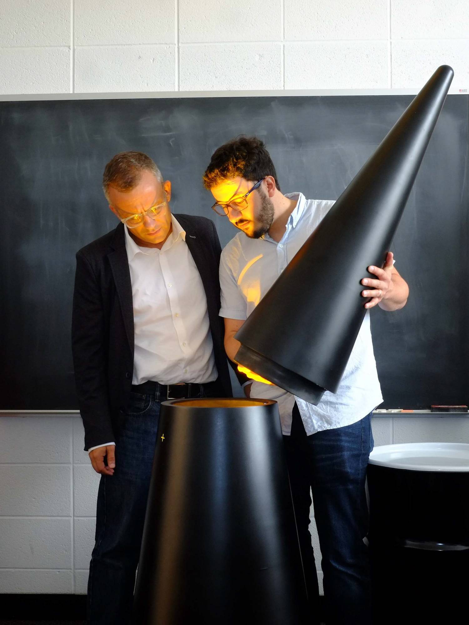 Two men stand in front of a chalkboard while the one on the left, SGS co-director Alexander Glaser, watches as research scholar Sébastien Philippe demonstrates a new approach to verifying nuclear warheads.