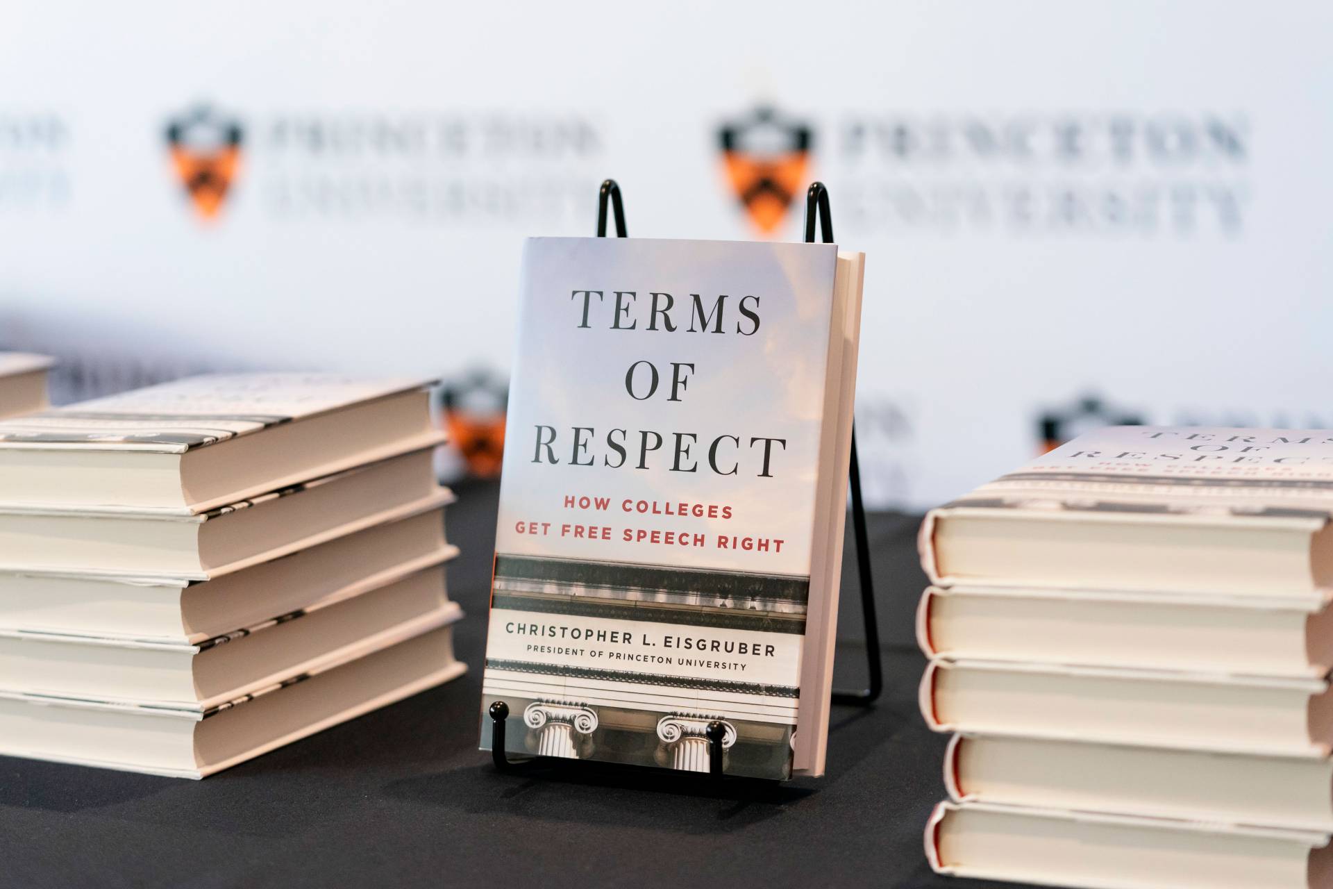 Copies of Eisgruber's book "Terms of Respect" stacked on a table for a book signing