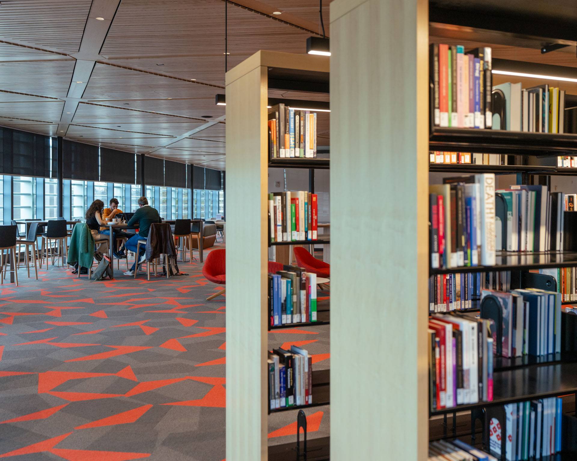 Students sit at a table in the Commons Library 