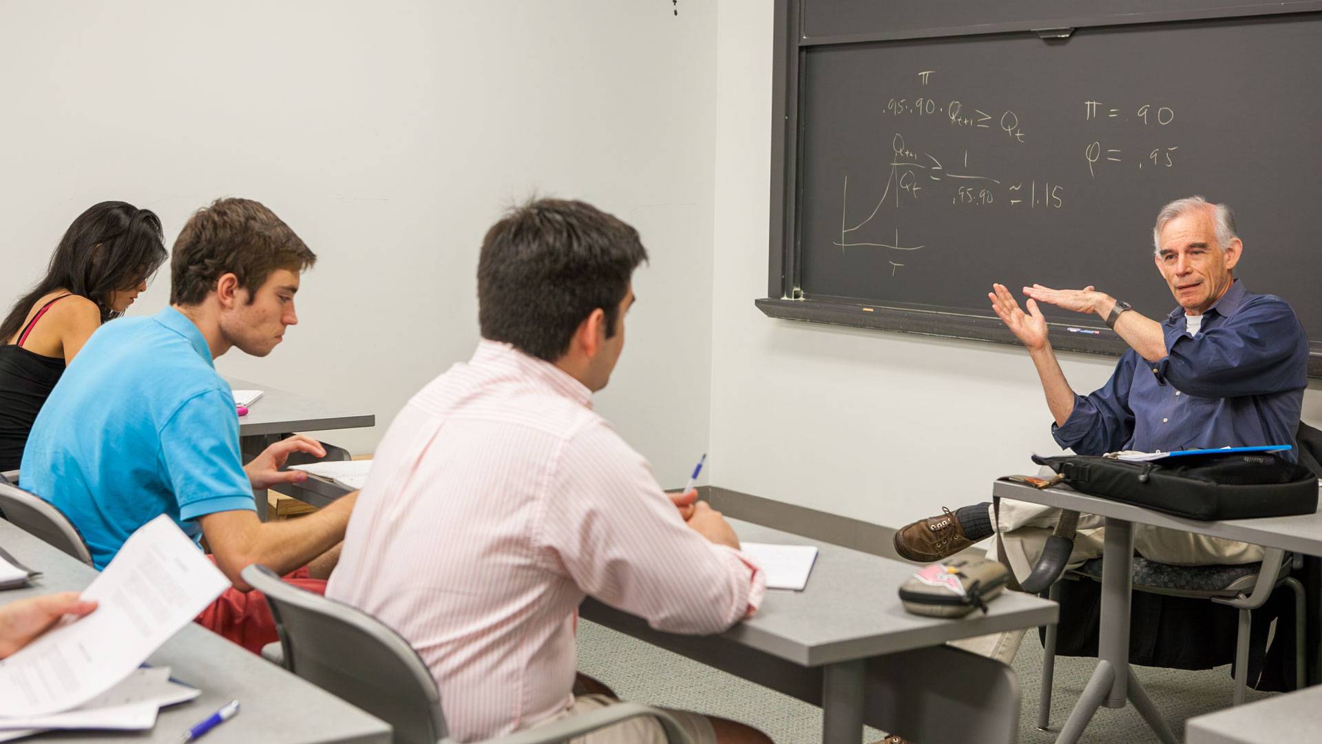 A "business-as-usual" Chris Sims teaches against a blackboard to students in his first Post-Nobels class