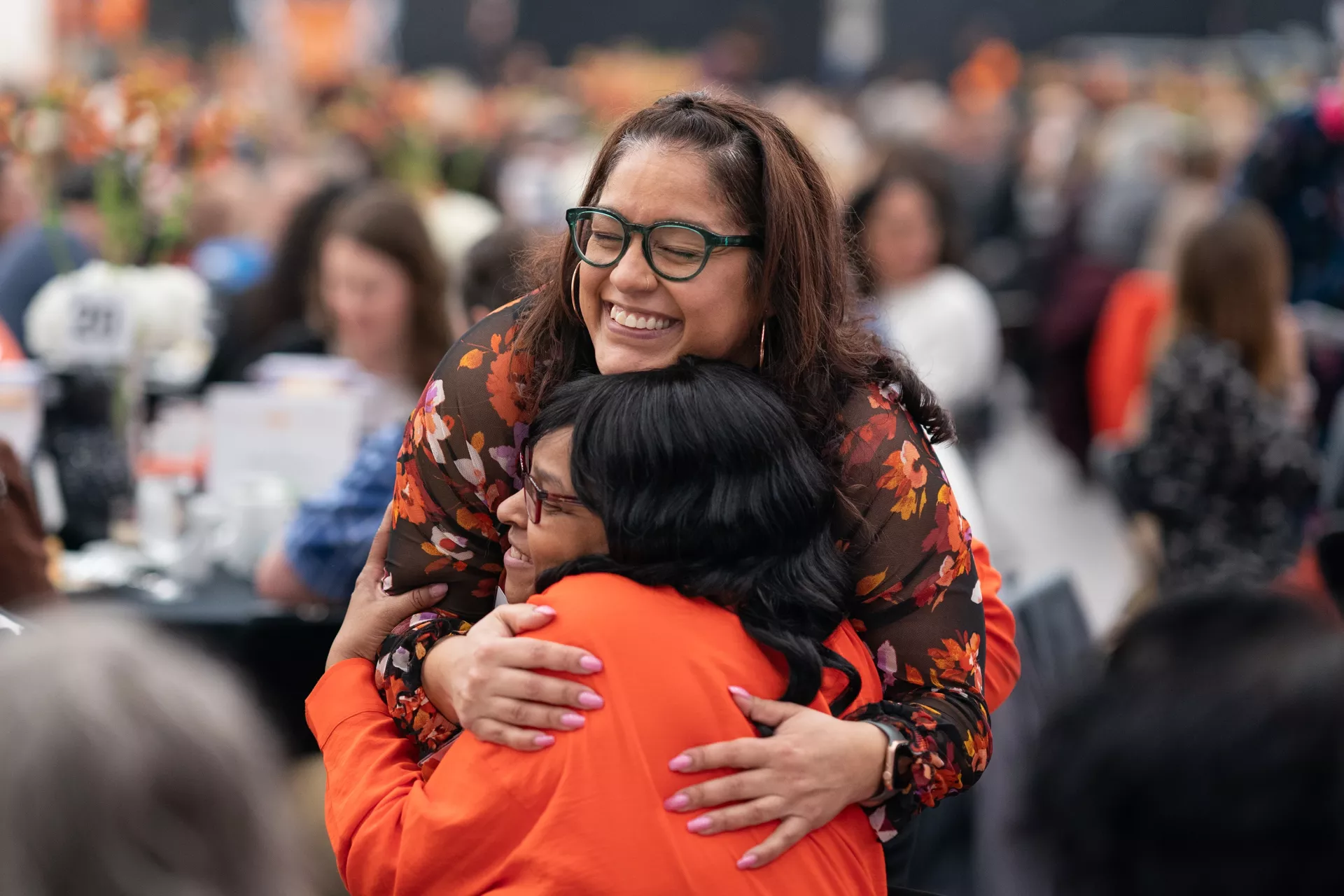 Two employees hug at the Service Recognition Lunch.