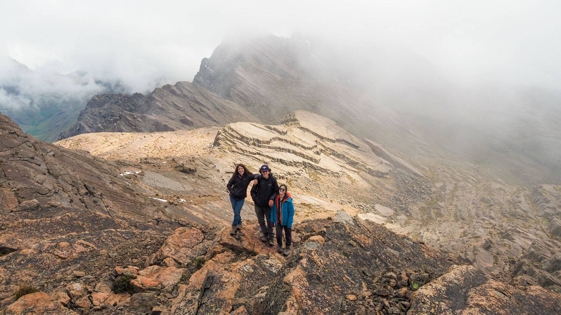 Three students on top of a mountain 