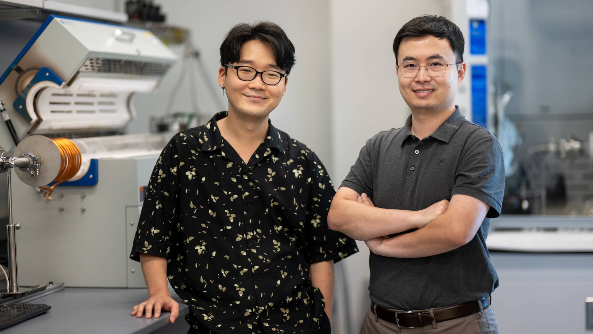 Two researchers standing in the lab where they make semiconductors.
