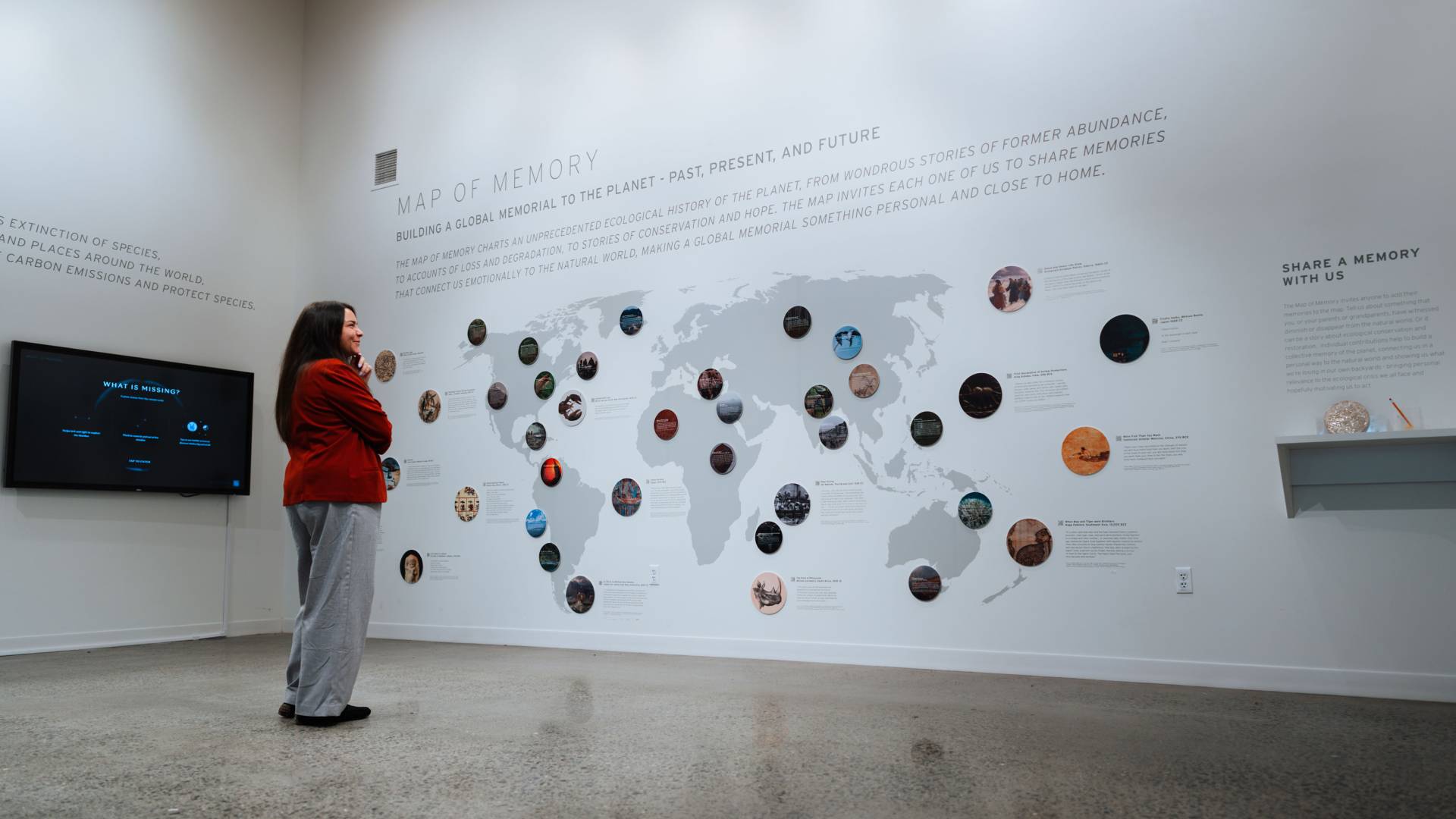 A visitor views a wall-length global map that is part of the interactive learning lab.
