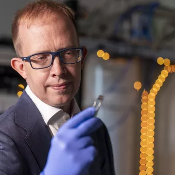 professor looks at a quantum microchip.