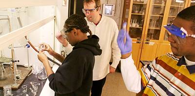 Bernhard helps student working under a fume hood