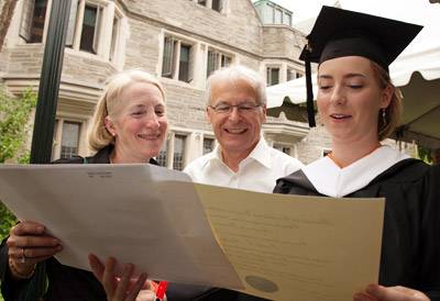 graduate and family examining diploma