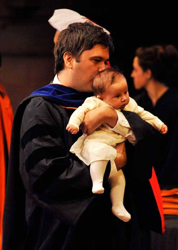 Mariano Somale, Ph.D. candidate in economics, holding his daughter Isabella Somale