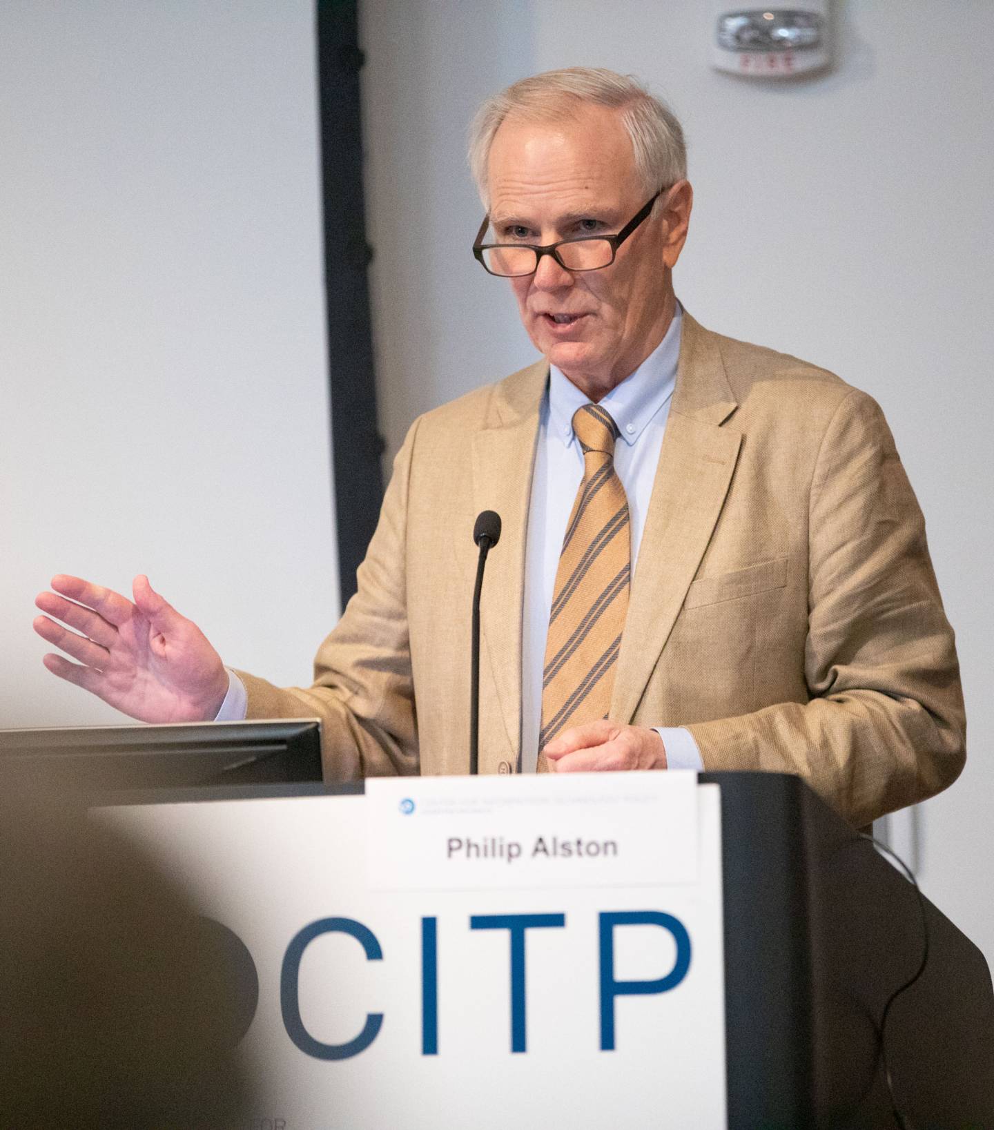 Philip Alston speaking at a podium with the CITP logo on it