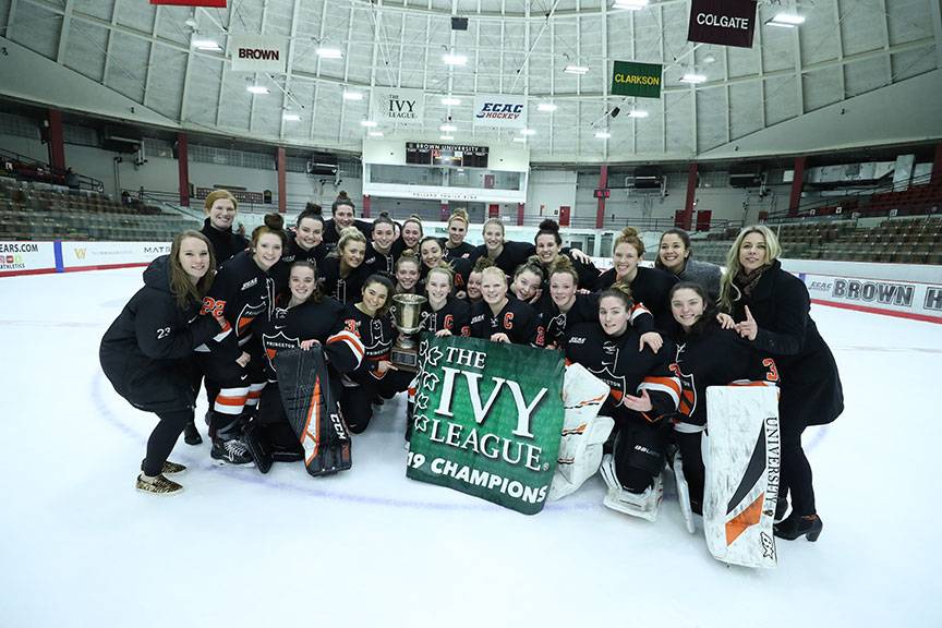 Princeton women's ice hockey team poses with their Ivy League Championship banner