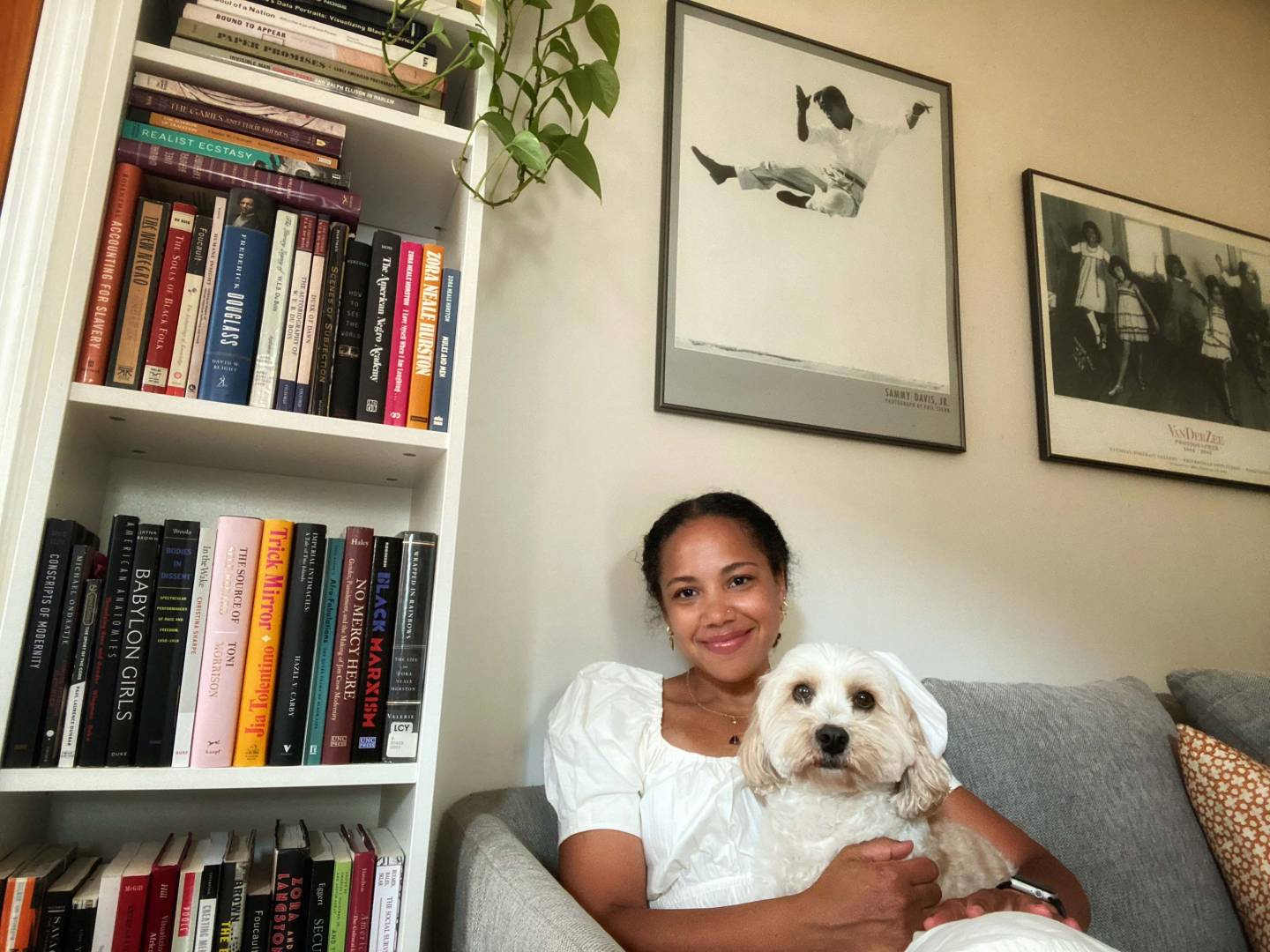 Autumn Womack with her dog next to bookshelves