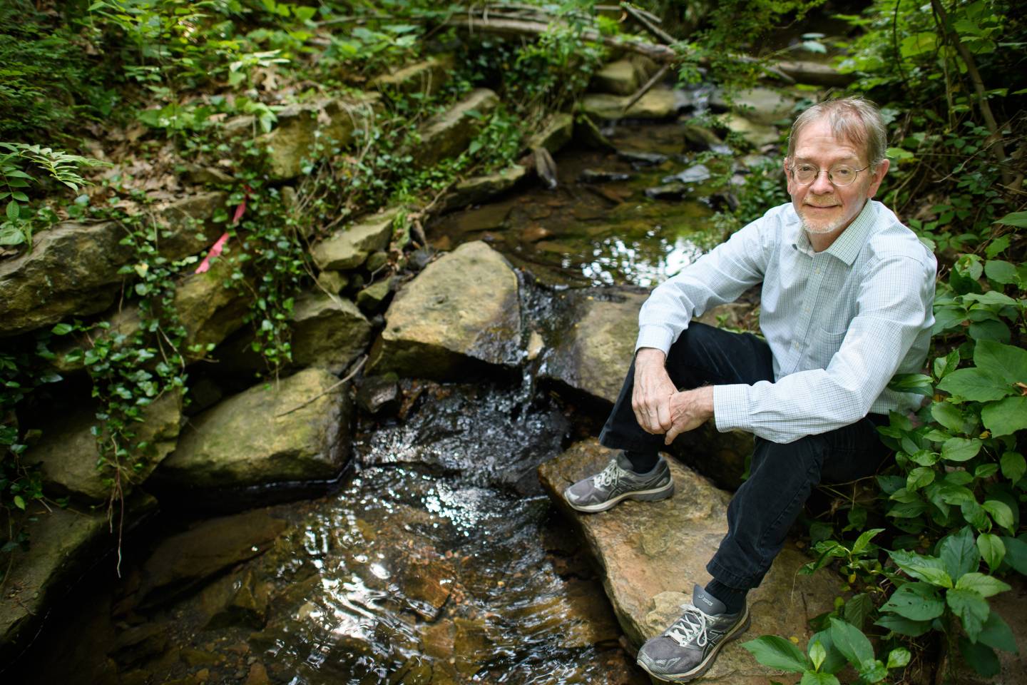 James Smith sits next to a stream