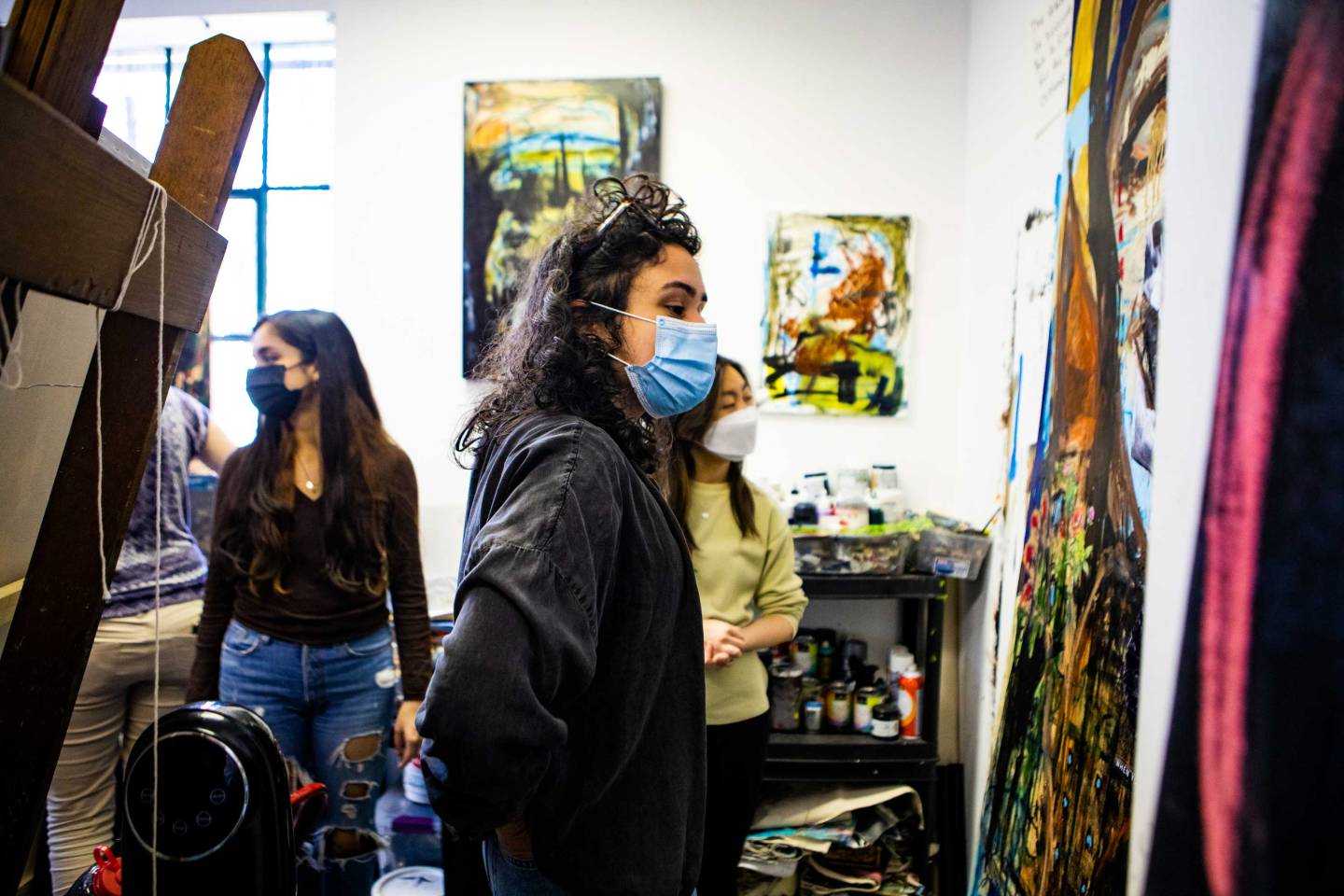 Students roam an artist's studio