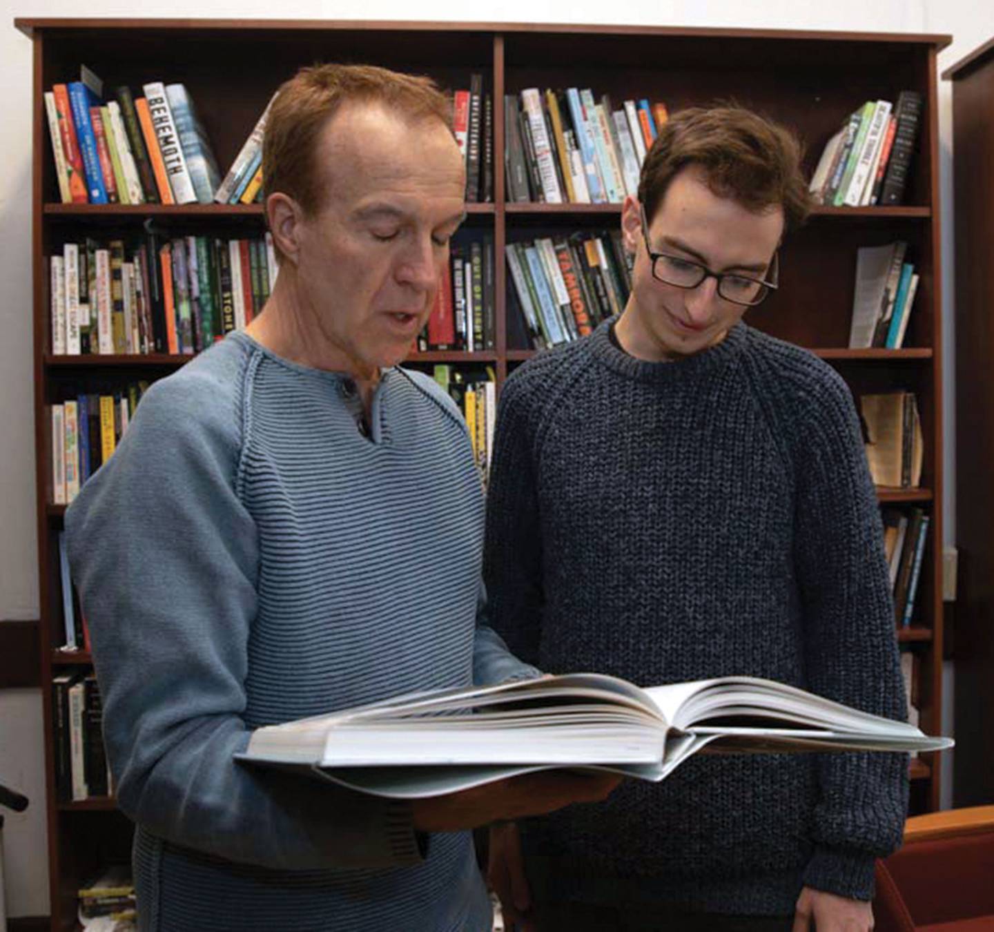 Robert Nixon and Jack Lohmann look at a large book