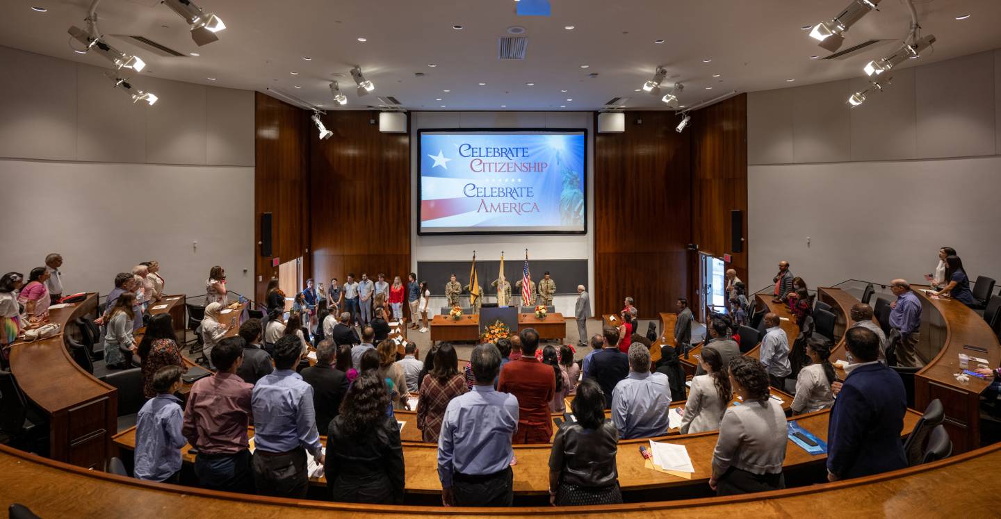 Naturalization ceremony participatns take the oath of allegiance.