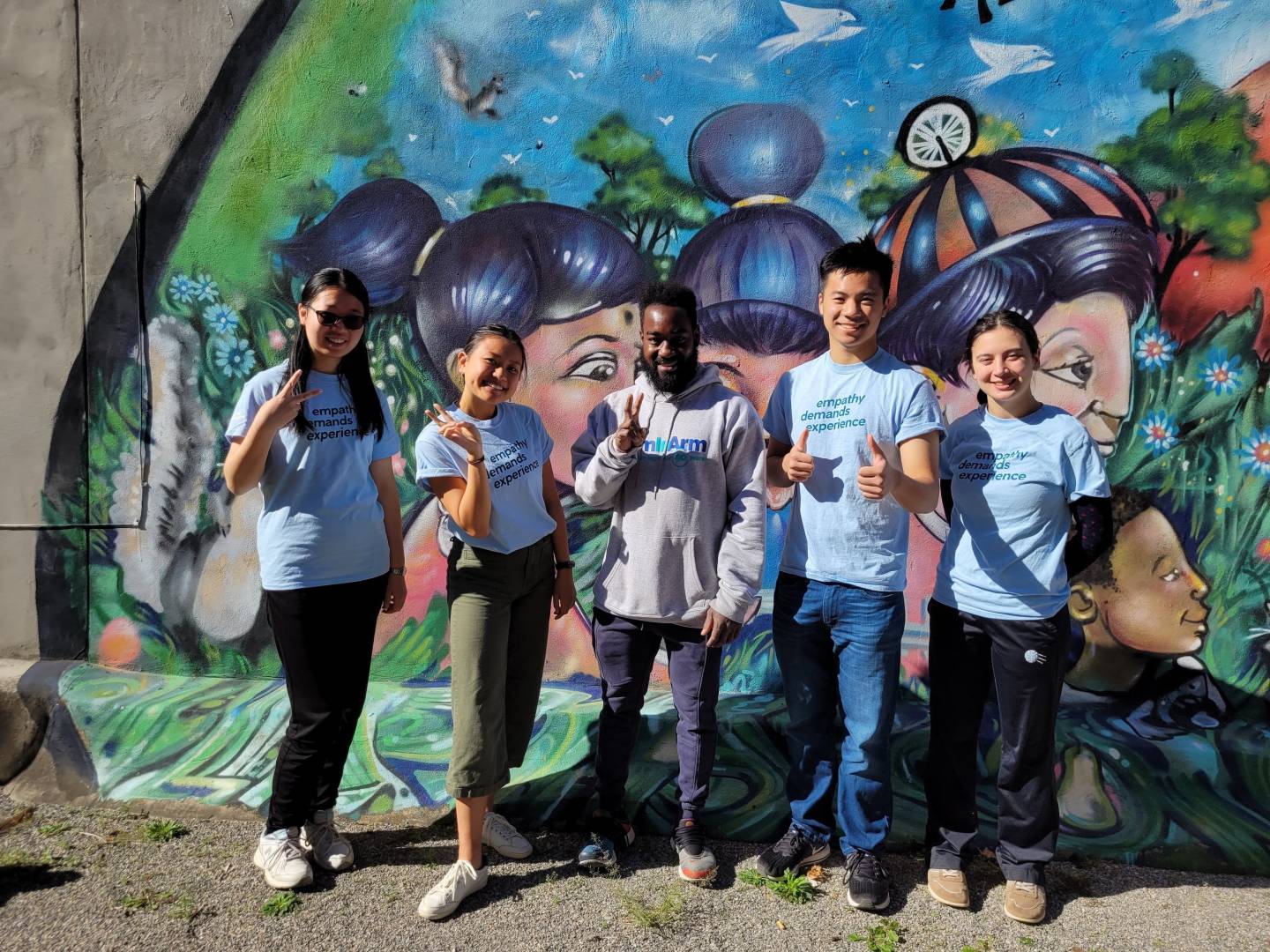 Students pose in front of a mural in Trenton