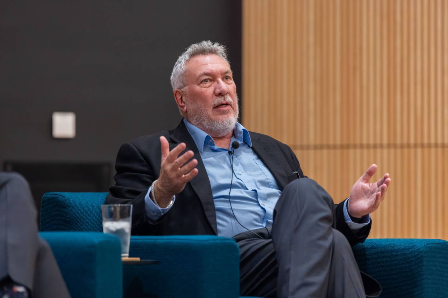 A bearded man speaks while sitting in a chair
