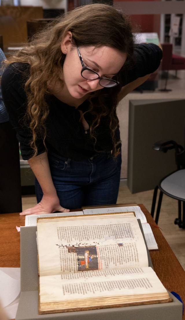 Student looking at ancient illuminated manuscript