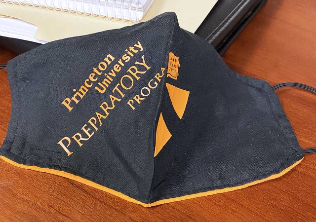 Black-and-orange face mask with the words Princeton University Preparatory Program printed on the front