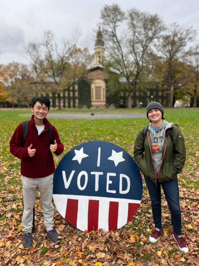 2 students in front of Nassau Hall with a big button that says "I voted"