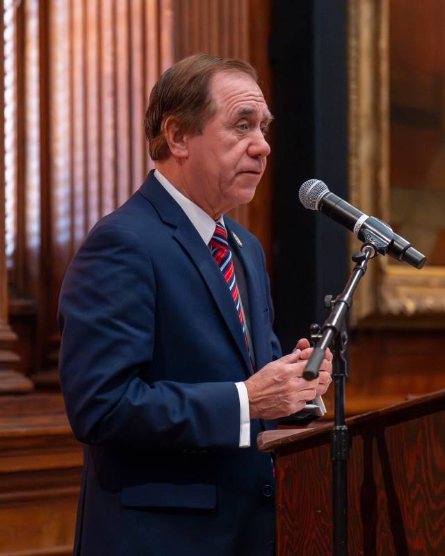 Assembly Speaker Craig Coughlin speaks from at podium into microphone