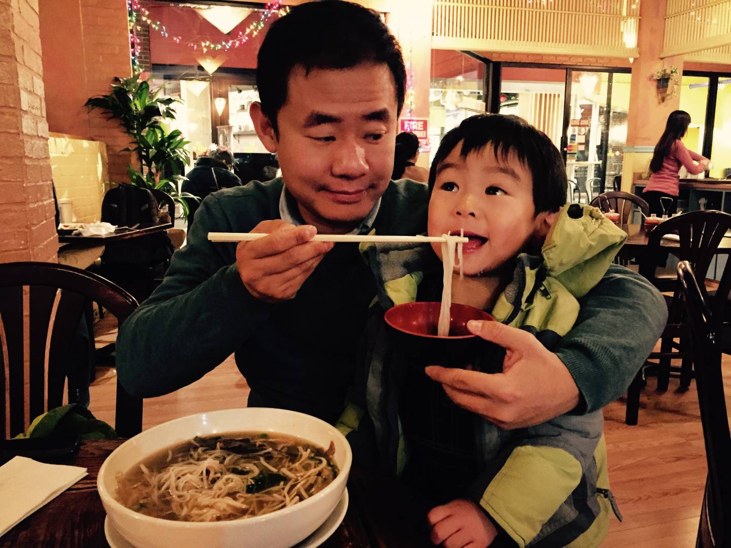Xiyue Wang feeding his son noodles